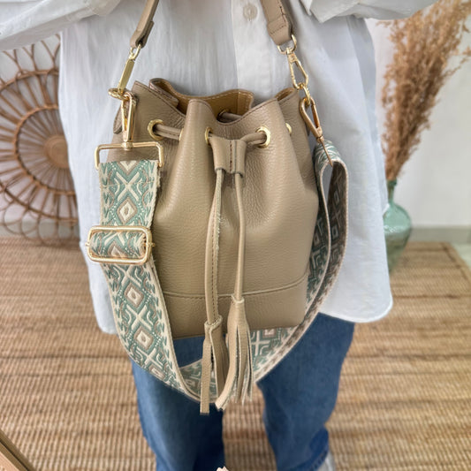 Bolso bucket piel taupe pompón iniciales bordadas