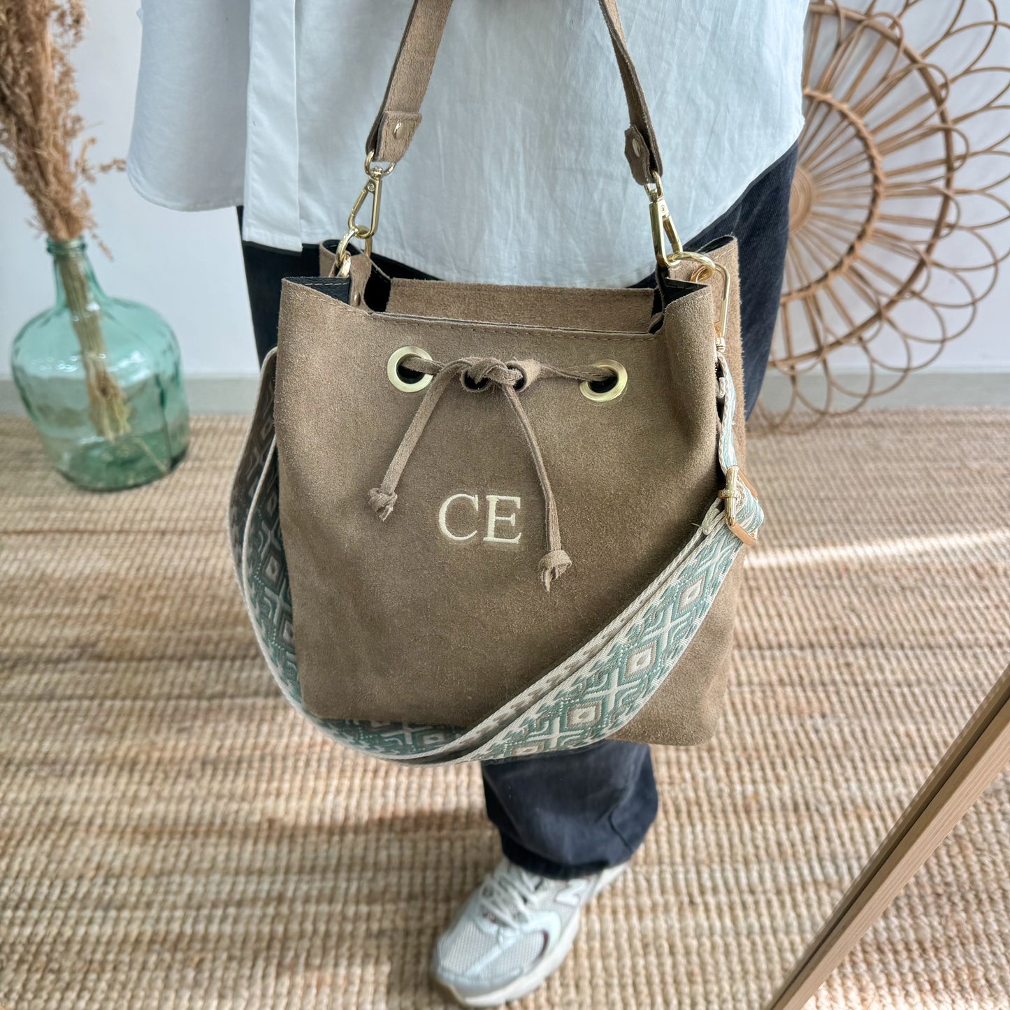 Bolso bucket serraje taupe arandelas herraje dorado iniciales bordadas
