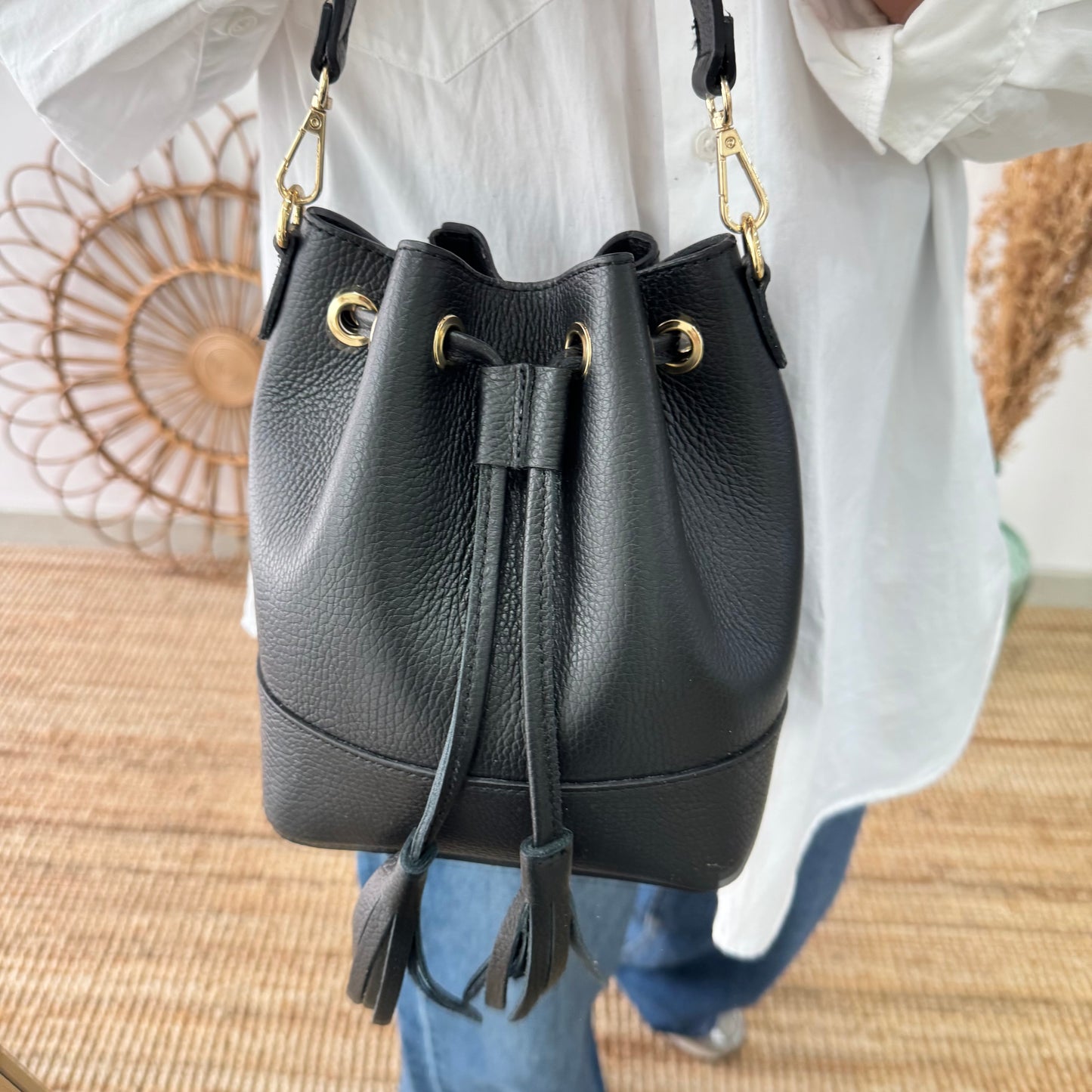 Bolso bucket piel negro pompón iniciales bordadas