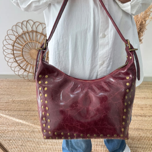 Bolso tachuelas piel granate iniciales bordadas