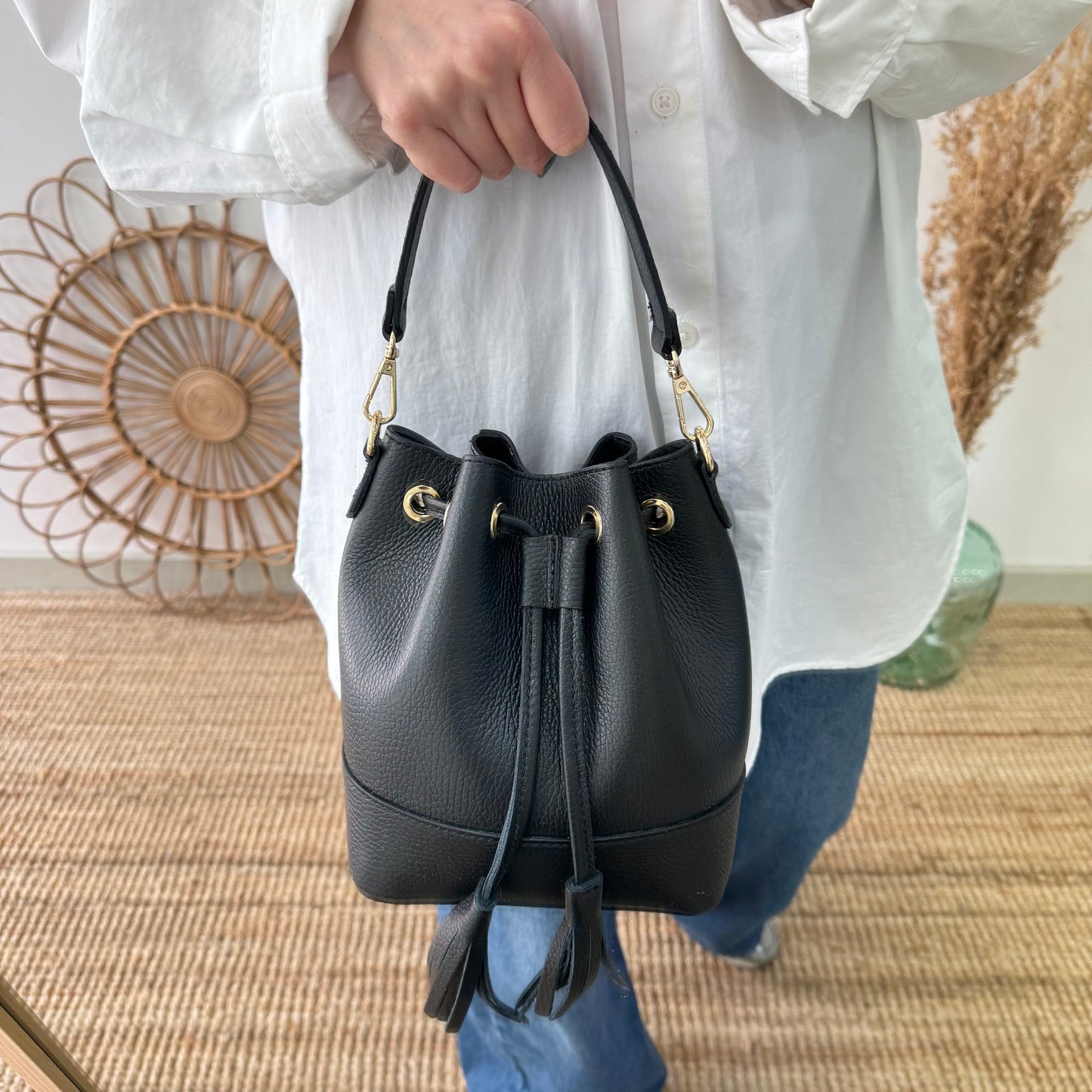 Bolso bucket piel negro pompón iniciales bordadas