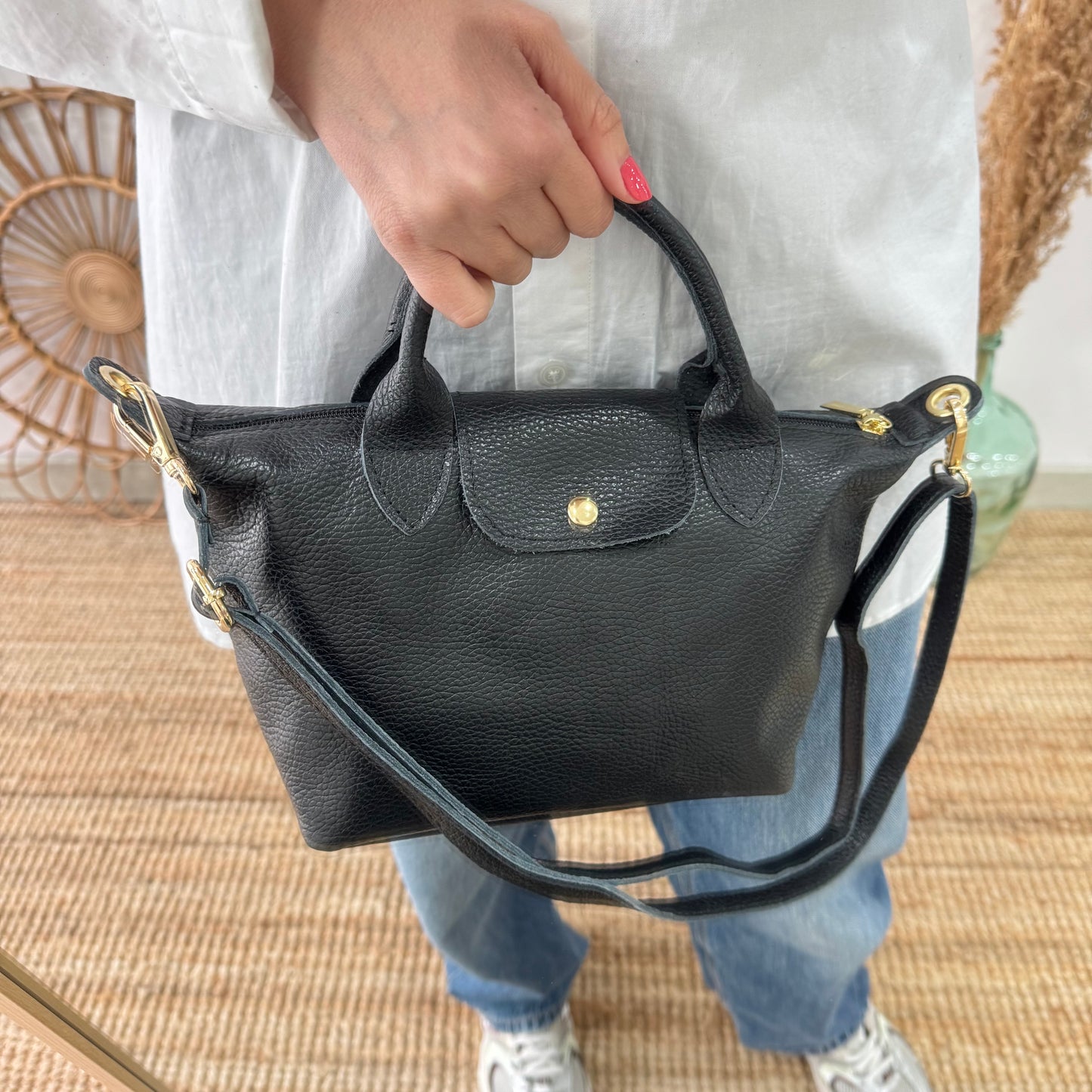 Bolso ovalado piel negra solapa iniciales bordadas