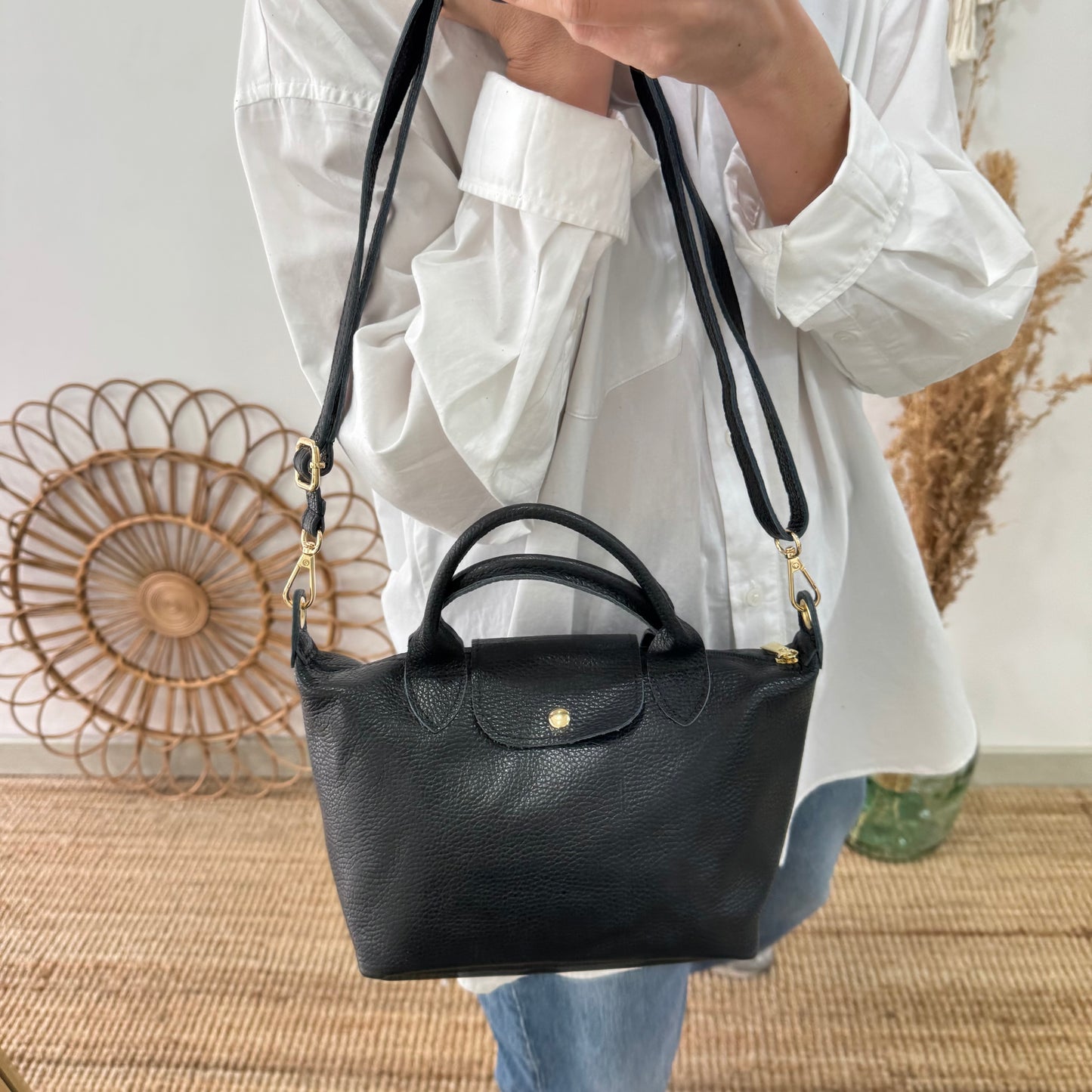 Bolso ovalado piel negra solapa iniciales bordadas
