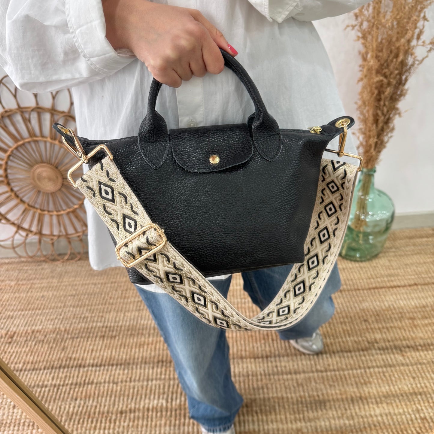 Bolso ovalado piel negra solapa iniciales bordadas
