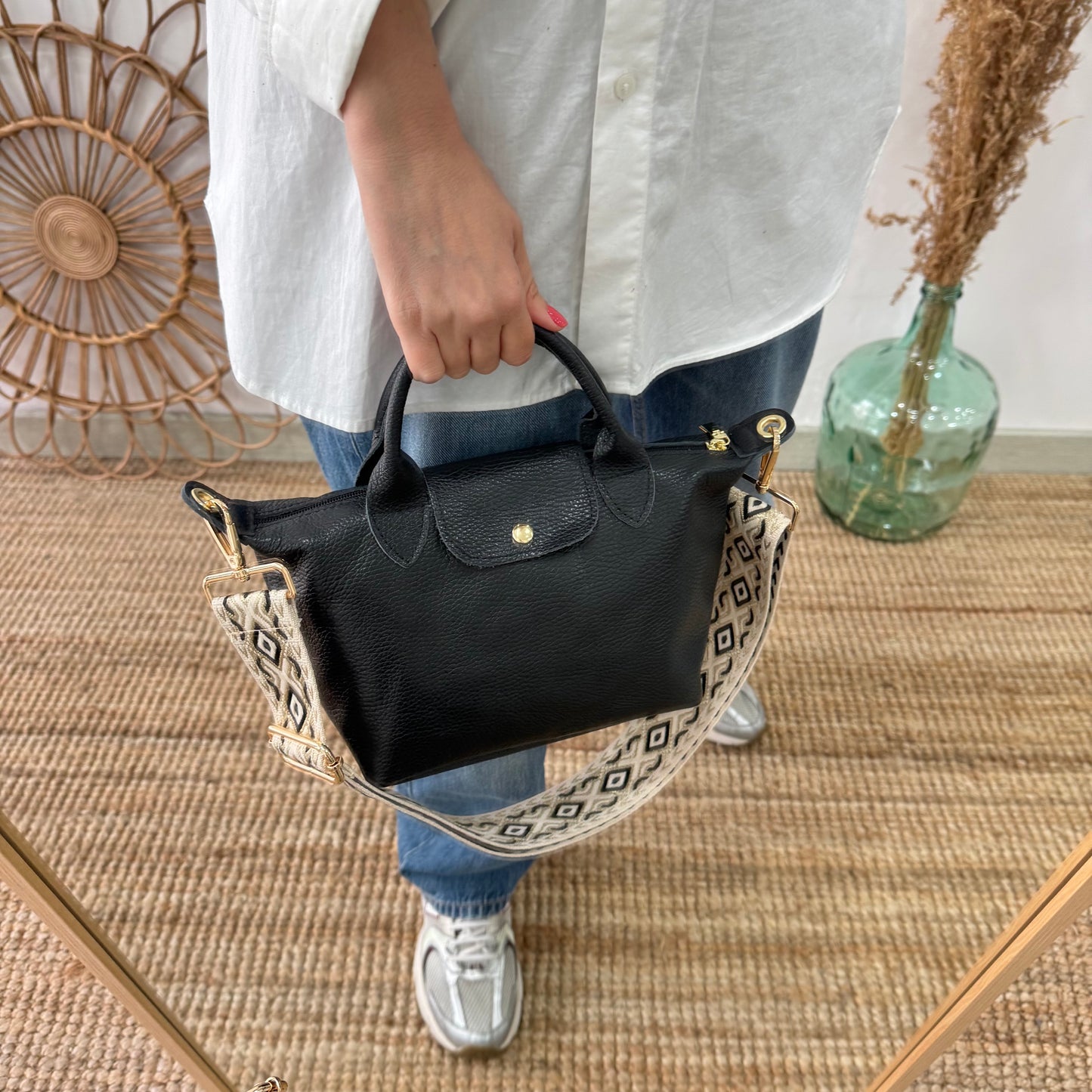 Bolso ovalado piel negra solapa iniciales bordadas