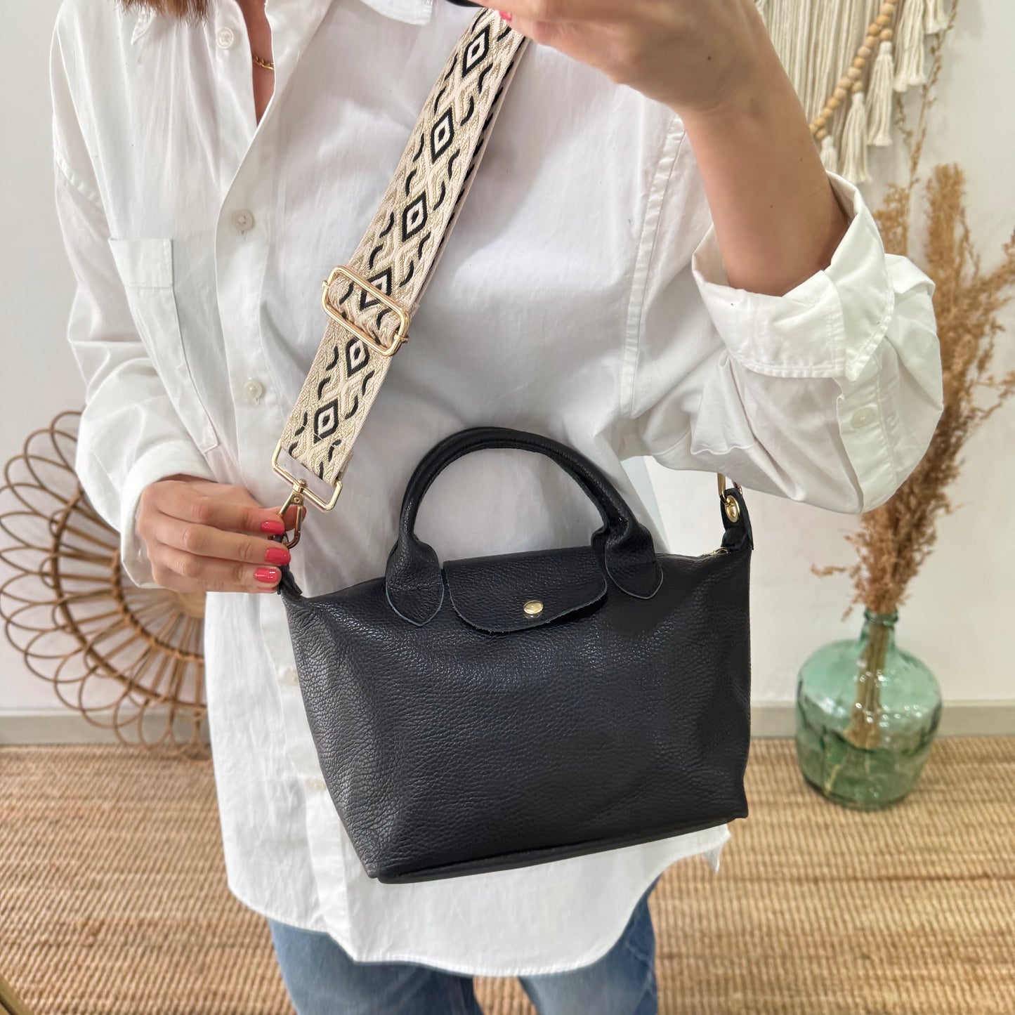 Bolso ovalado piel negra solapa iniciales bordadas