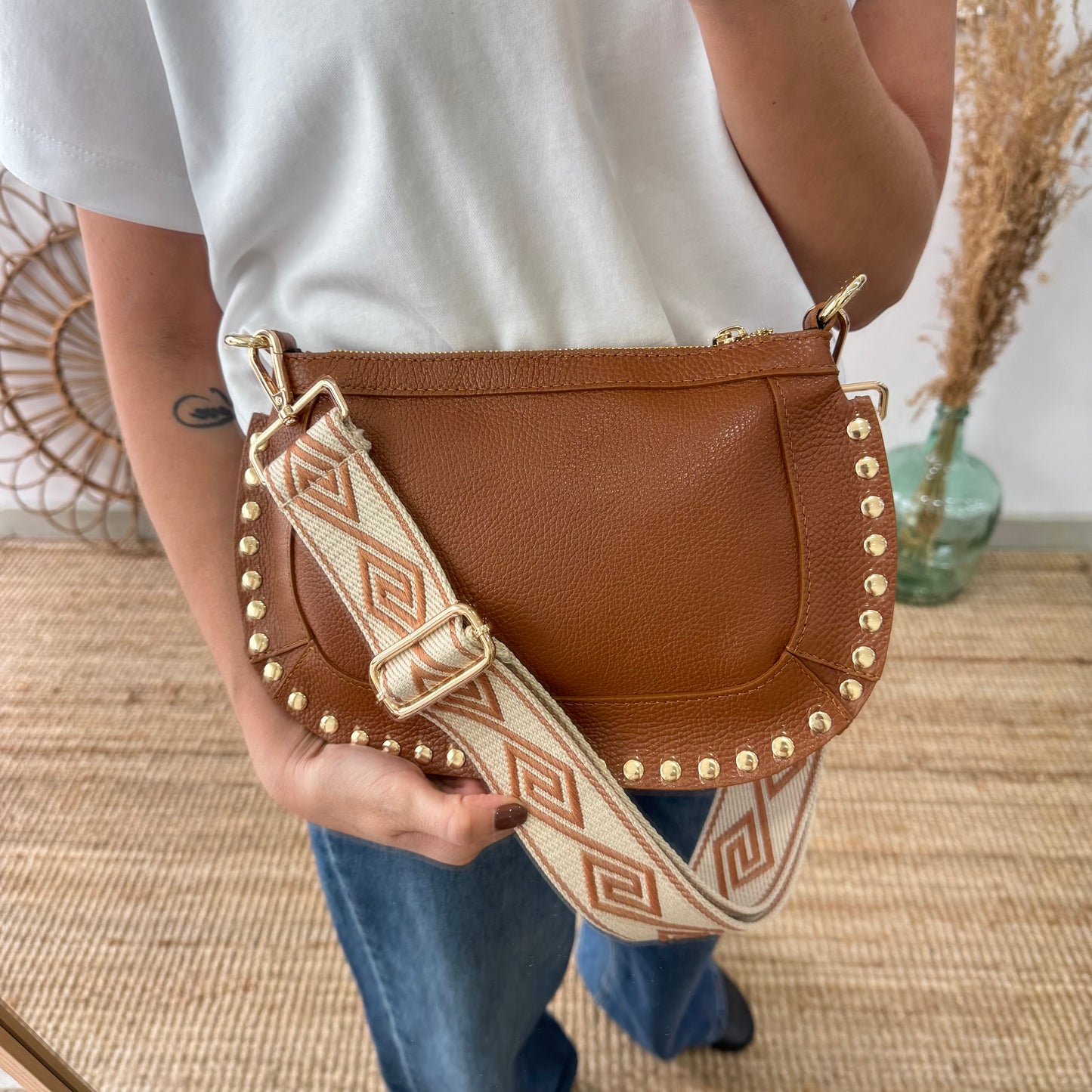 Bandolera ovalada piel tachuelas camel iniciales bordadas