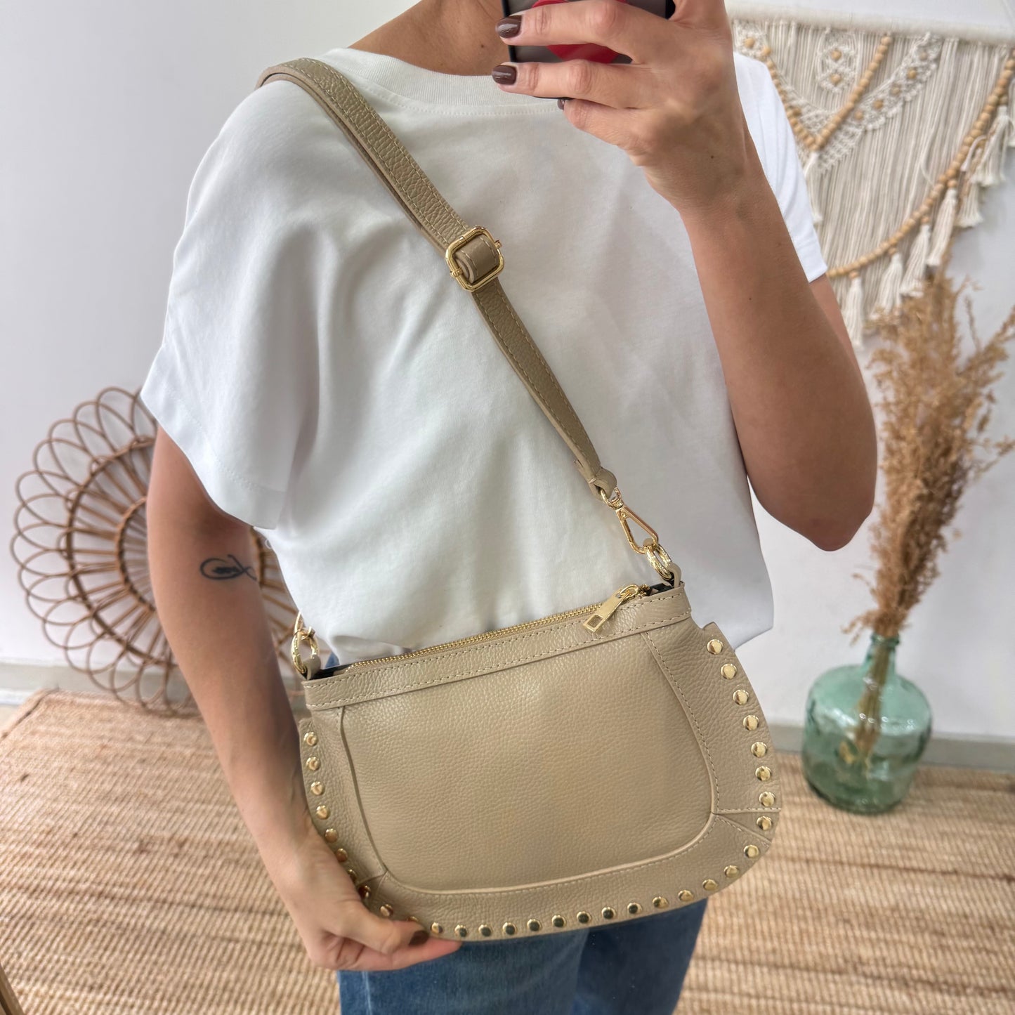 Bandolera ovalada piel tachuelas taupe iniciales bordadas