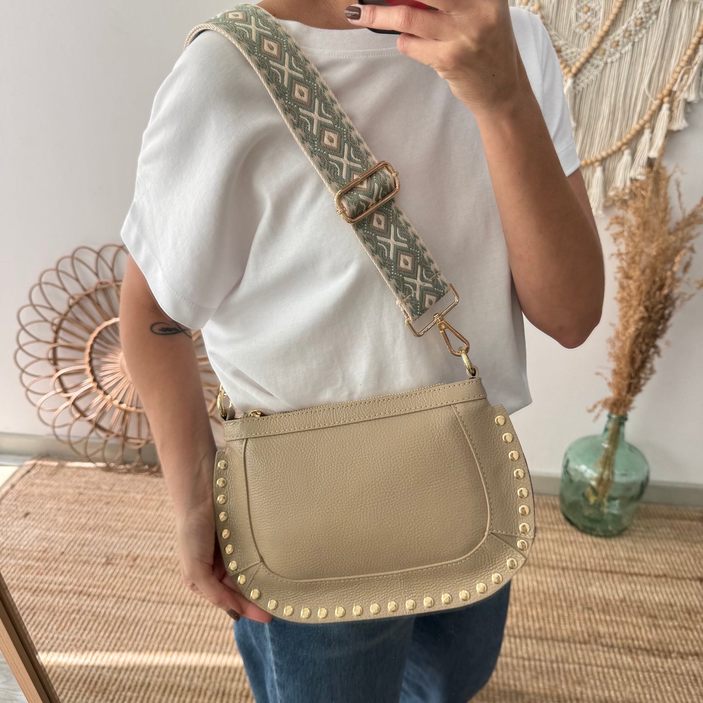 Bandolera ovalada piel tachuelas taupe iniciales bordadas