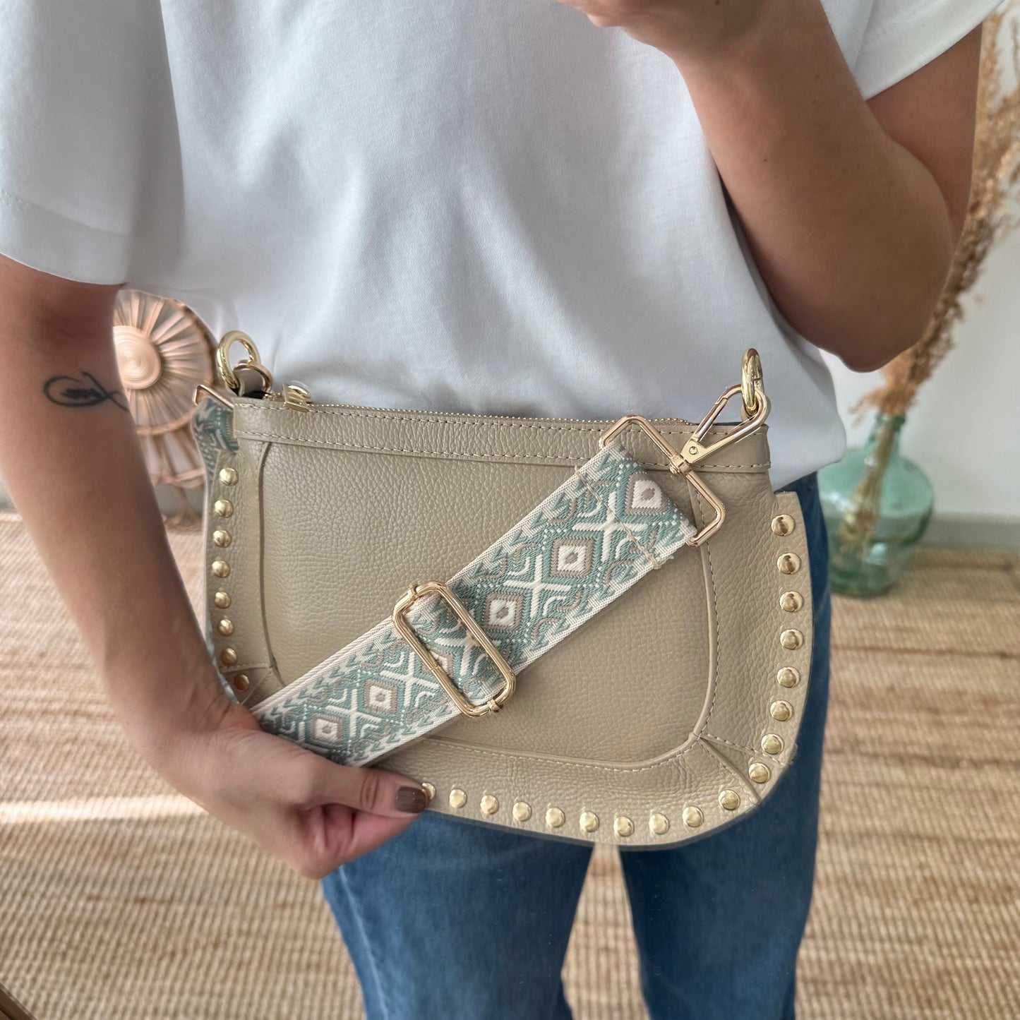 Bandolera ovalada piel tachuelas taupe iniciales bordadas