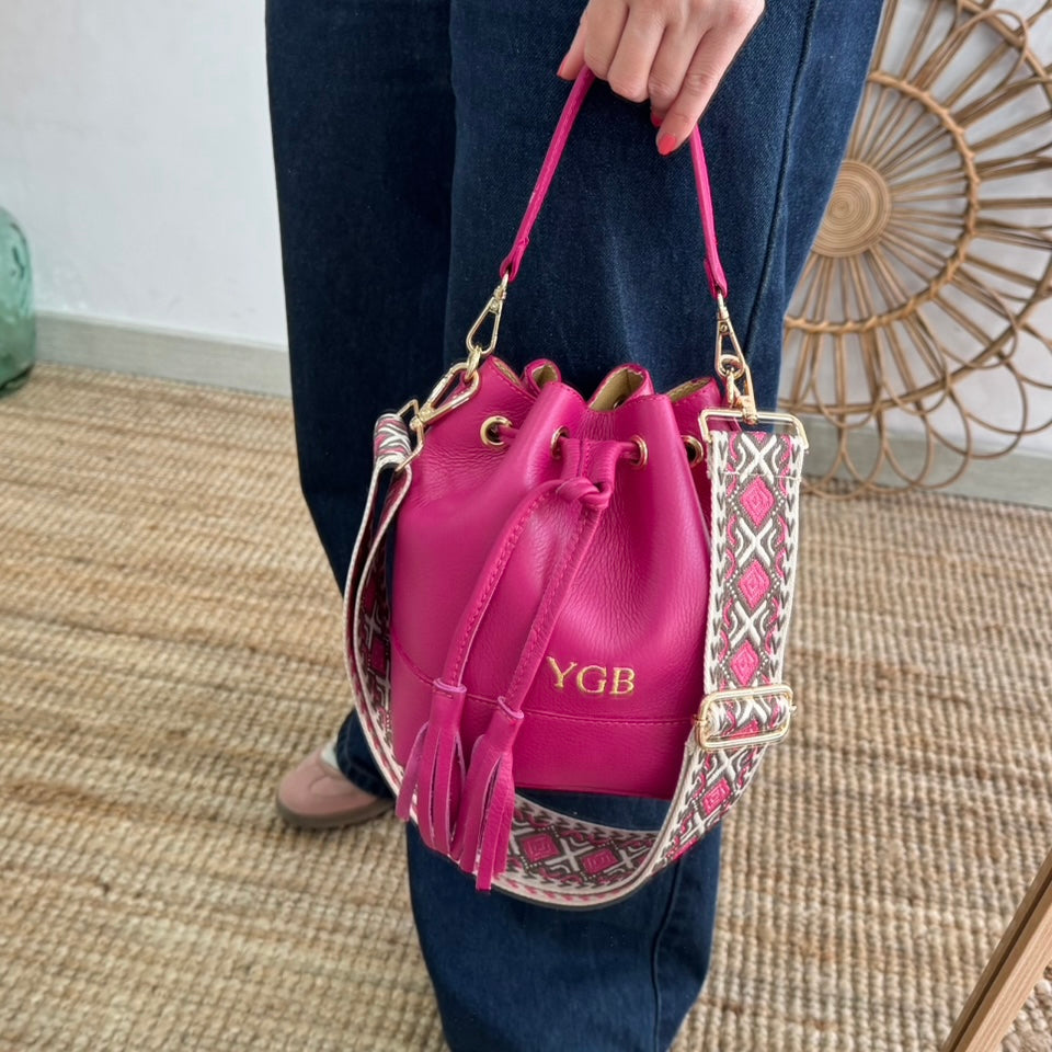 Bolso bucket piel fucsia pompón iniciales bordadas