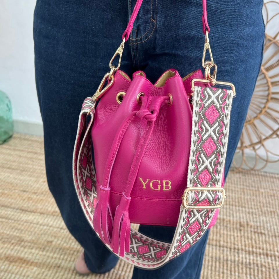 Bolso bucket piel fucsia pompón iniciales bordadas