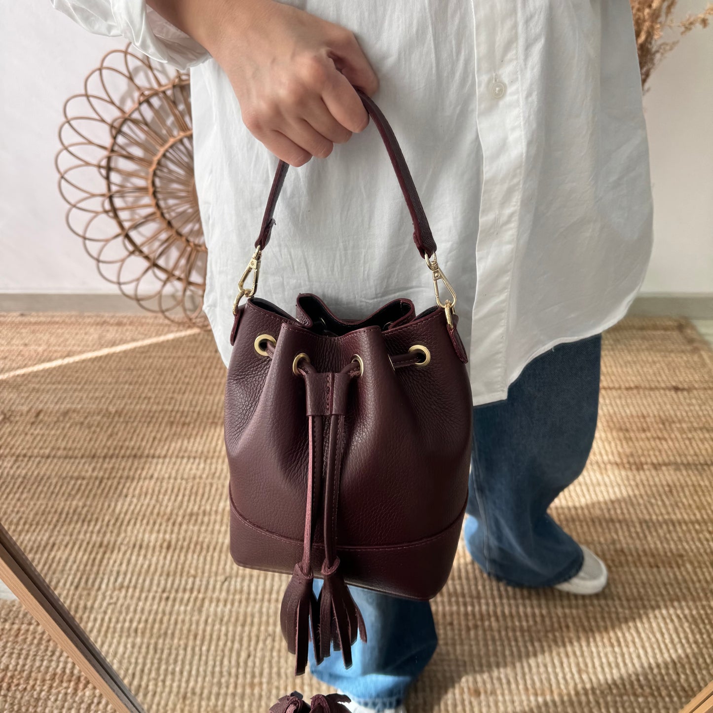 Bolso bucket piel granate pompón iniciales bordadas