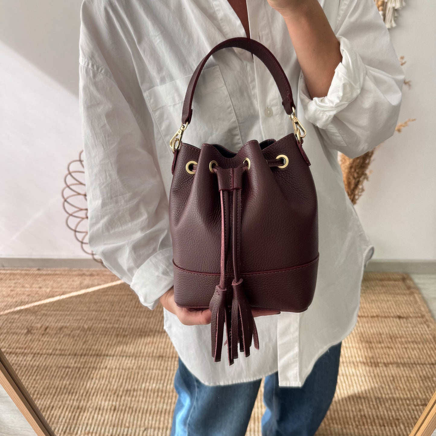 Bolso bucket piel granate pompón iniciales bordadas