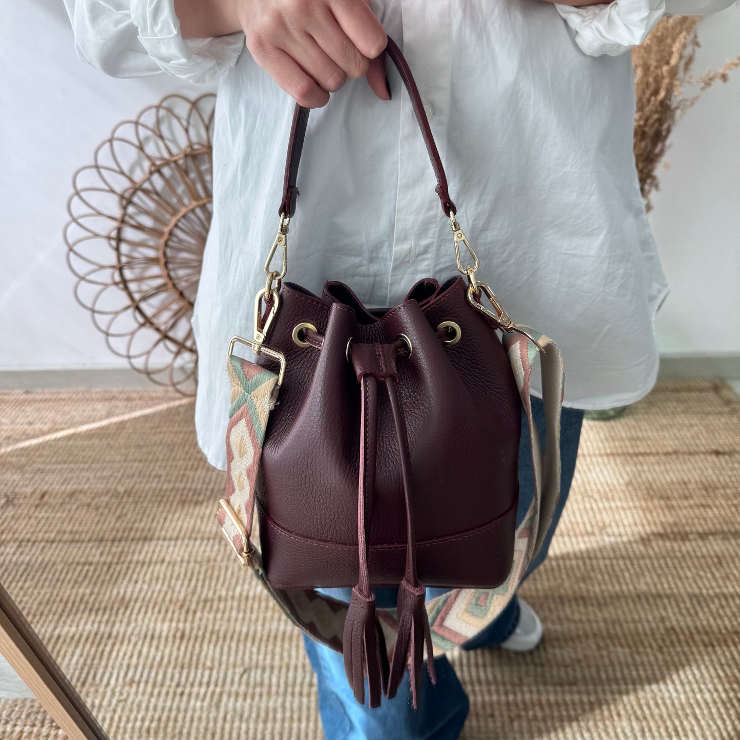 Bolso bucket piel granate pompón iniciales bordadas