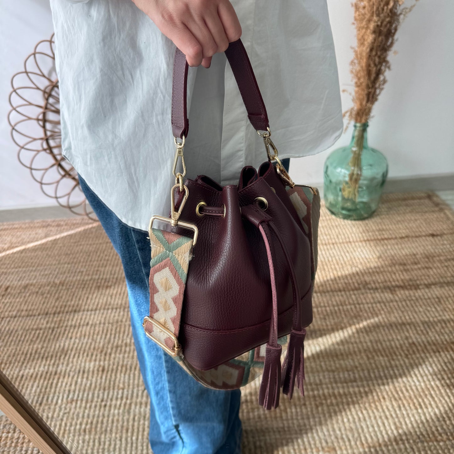 Bolso bucket piel granate pompón iniciales bordadas