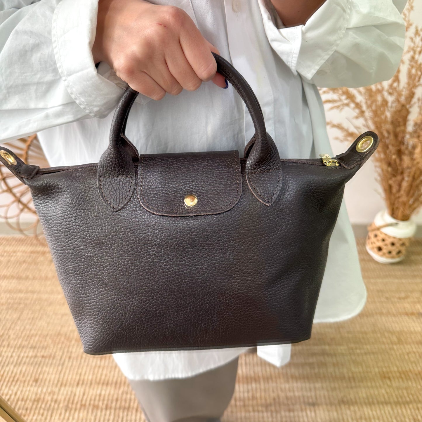 Bolso ovalado piel marrón solapa iniciales bordadas