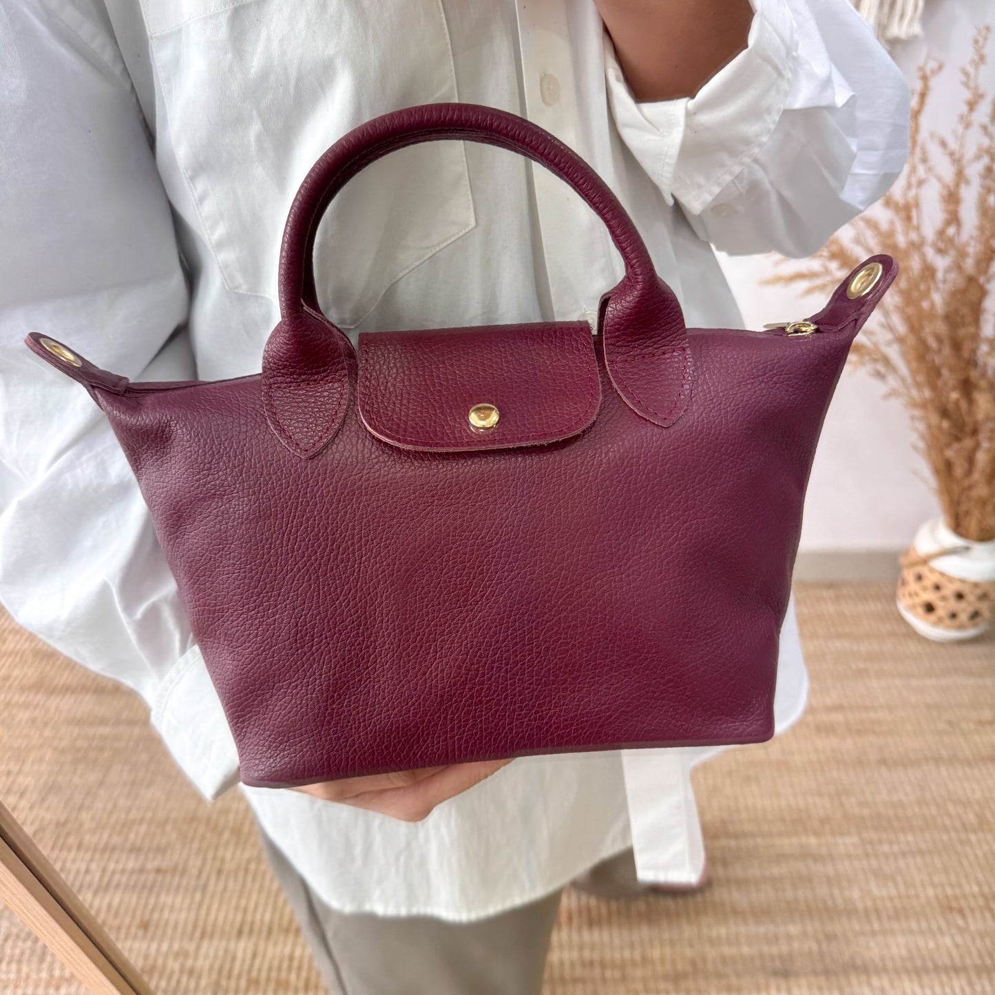 Bolso ovalado piel granate solapa iniciales bordadas