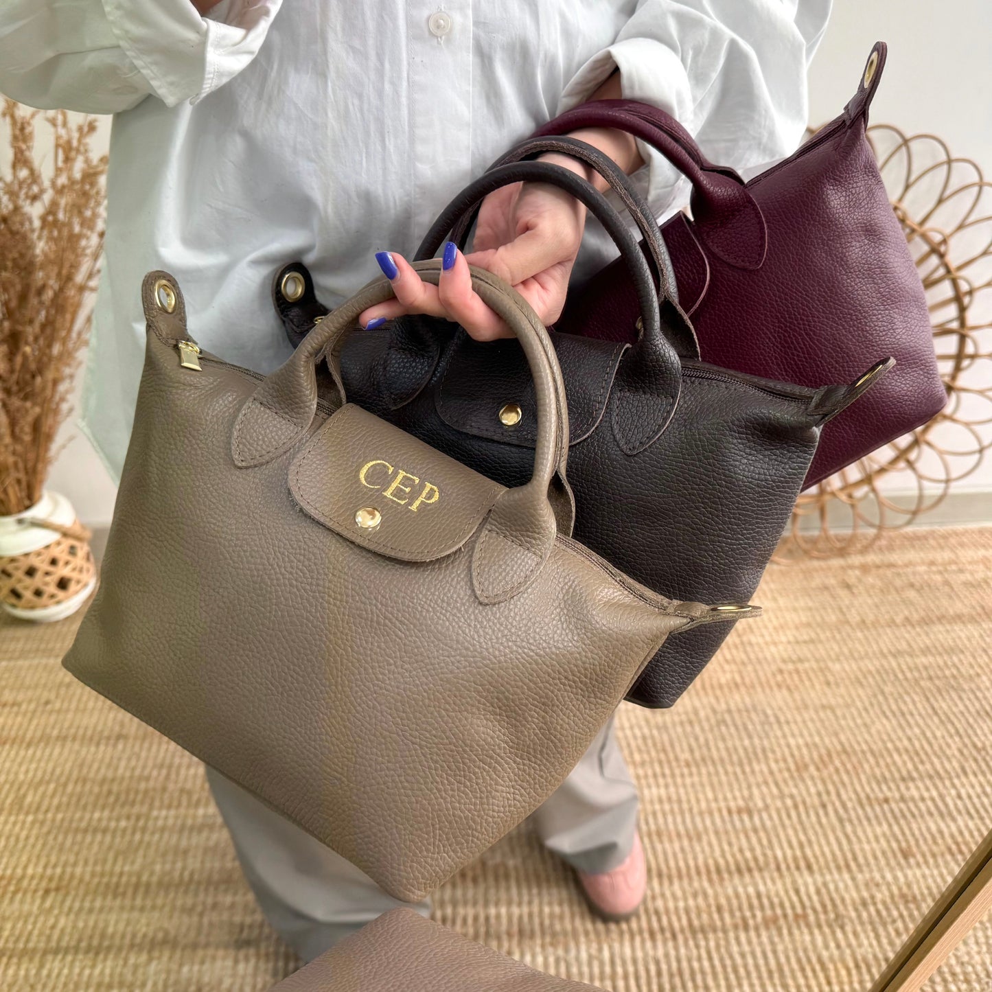 Bolso ovalado piel marrón solapa iniciales bordadas