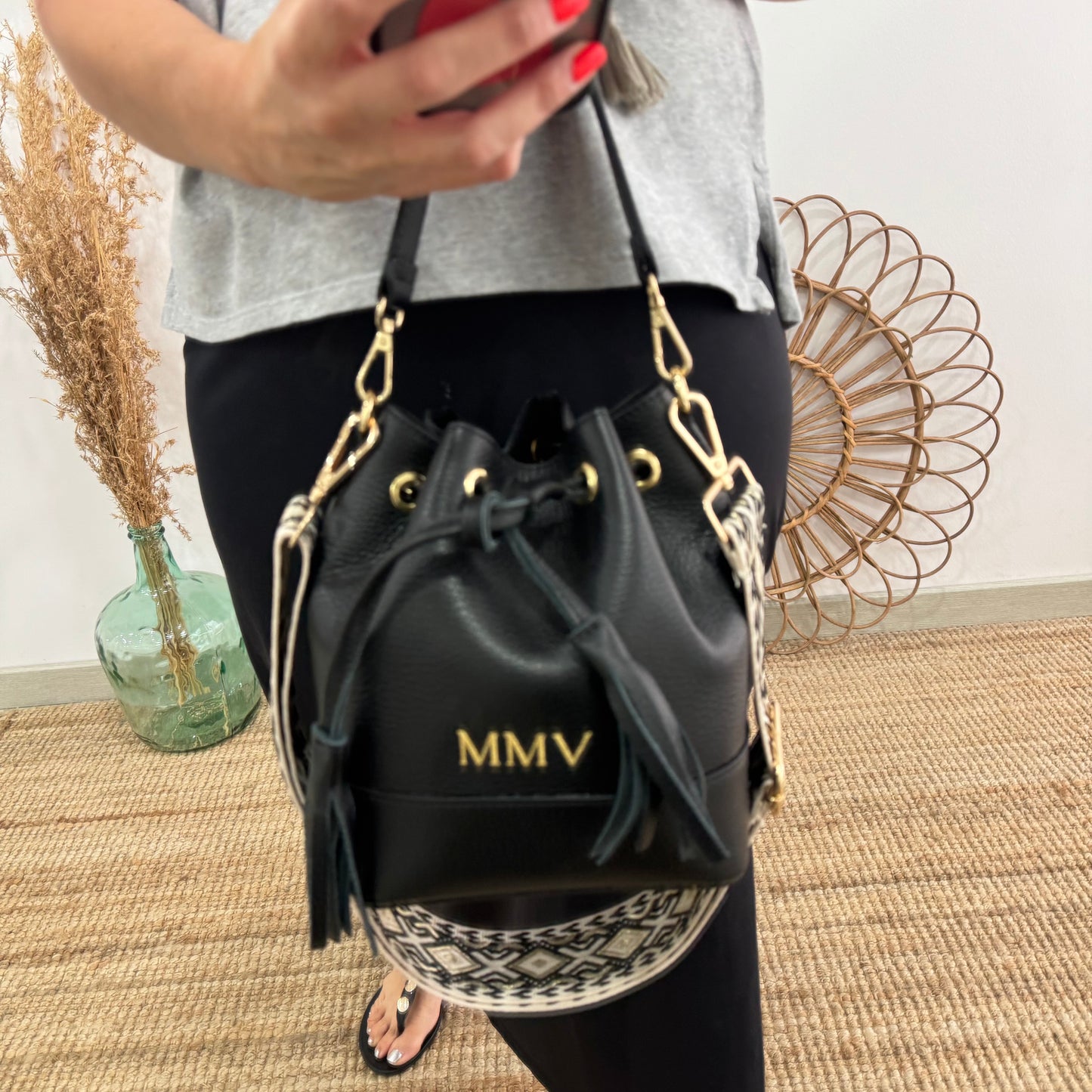 Bolso bucket piel negro pompón iniciales bordadas