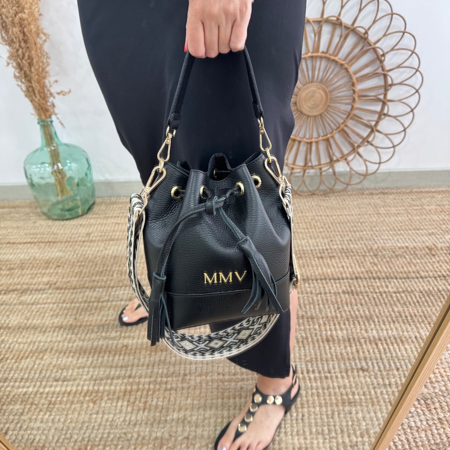Bolso bucket piel negro pompón iniciales bordadas
