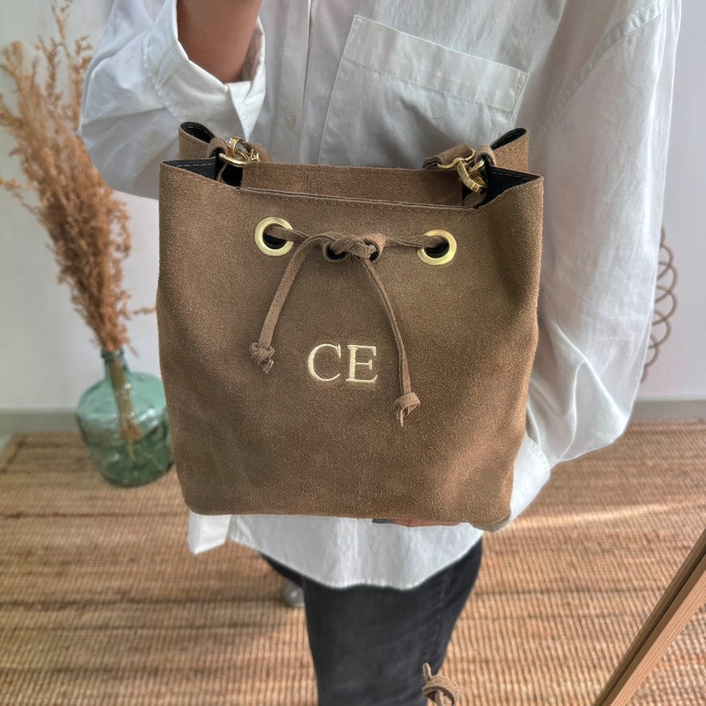 Bolso bucket serraje taupe arandelas herraje dorado iniciales bordadas