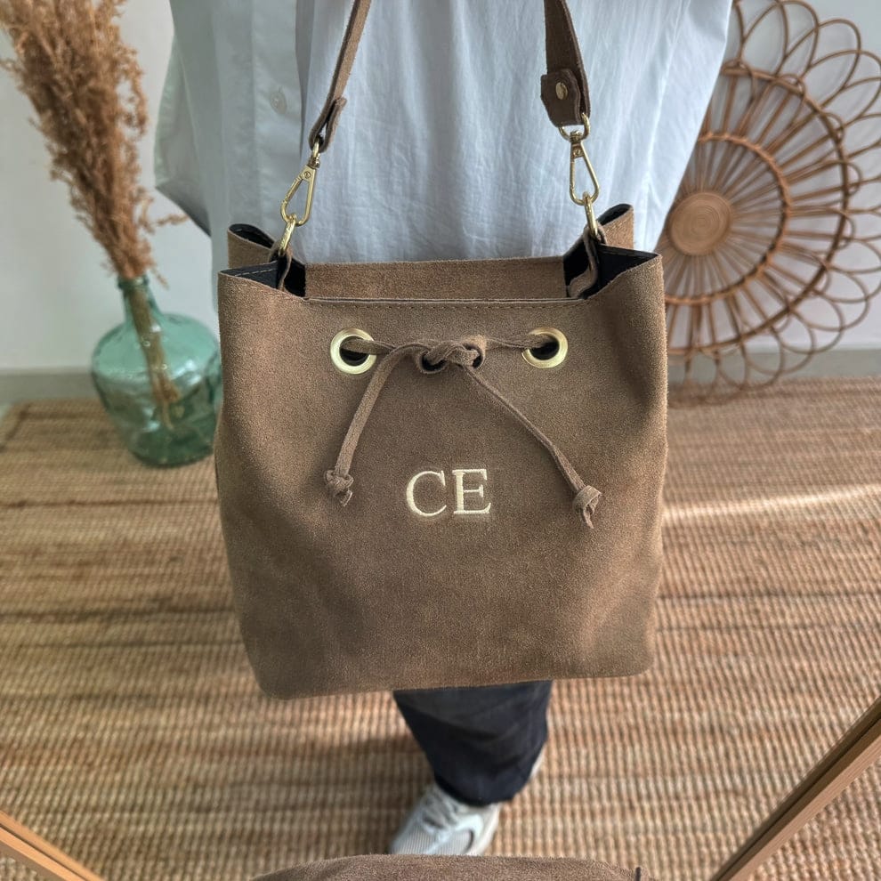 Bolso bucket serraje taupe arandelas herraje dorado iniciales bordadas