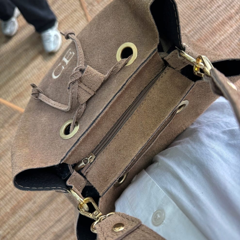 Bolso bucket serraje taupe arandelas herraje dorado iniciales bordadas