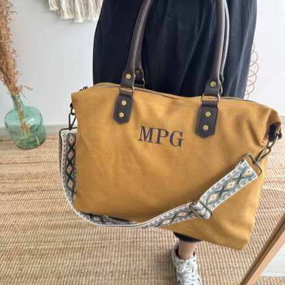 Bolso combinado loneta y piel mostaza iniciales bordadas con correa étnica