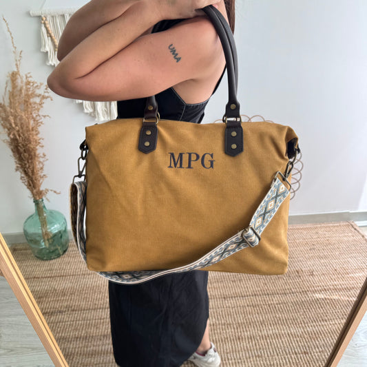 Bolso combinado loneta y piel mostaza iniciales bordadas con correa étnica