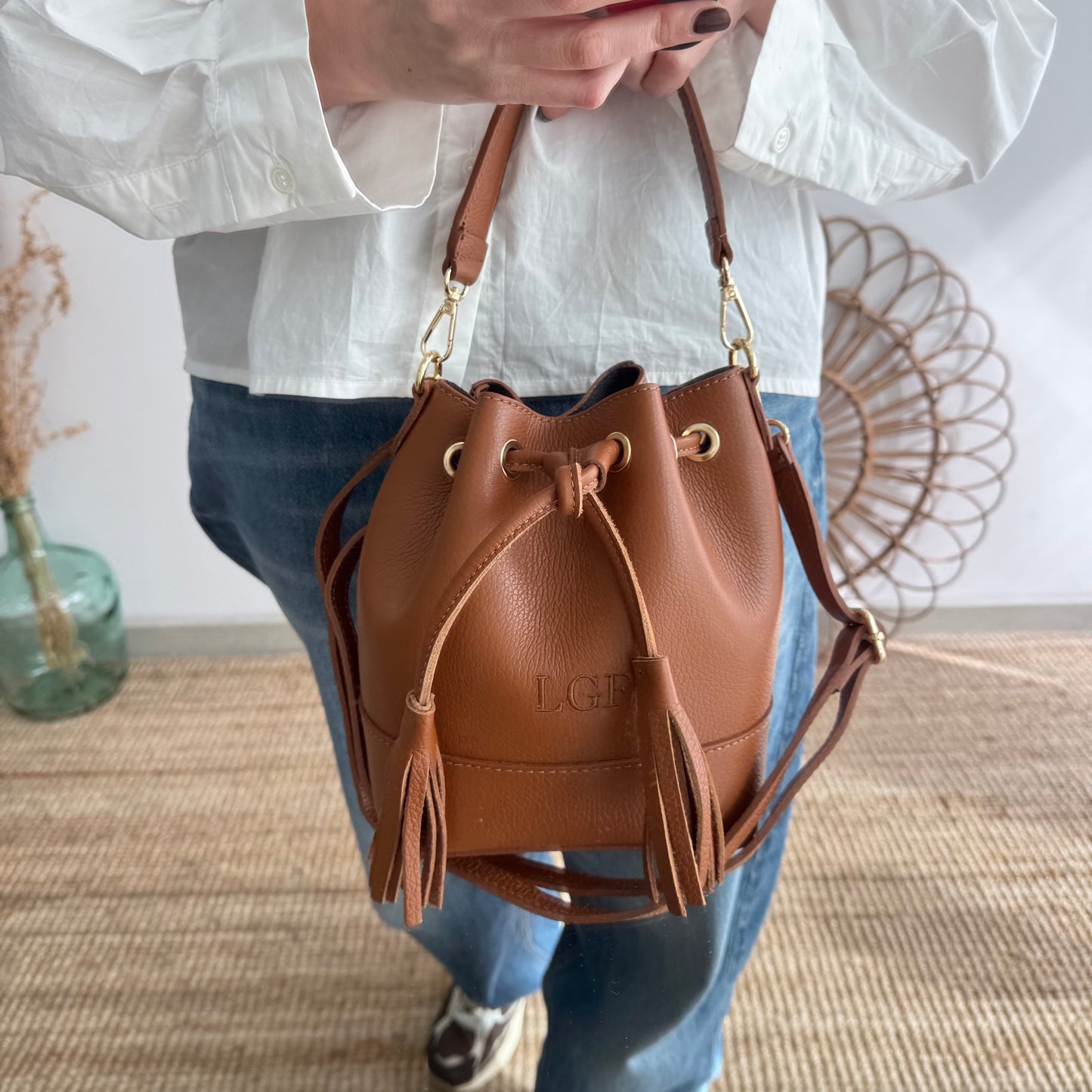 Bolso bucket piel camel pompón iniciales bordadas