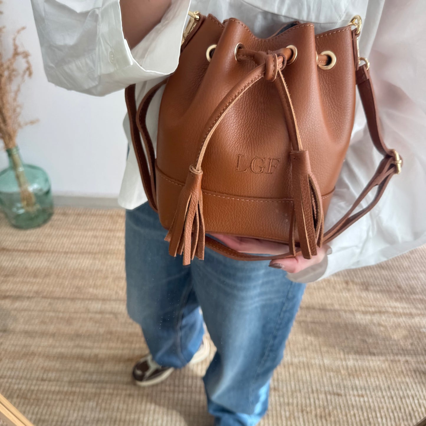 Bolso bucket piel camel pompón iniciales bordadas
