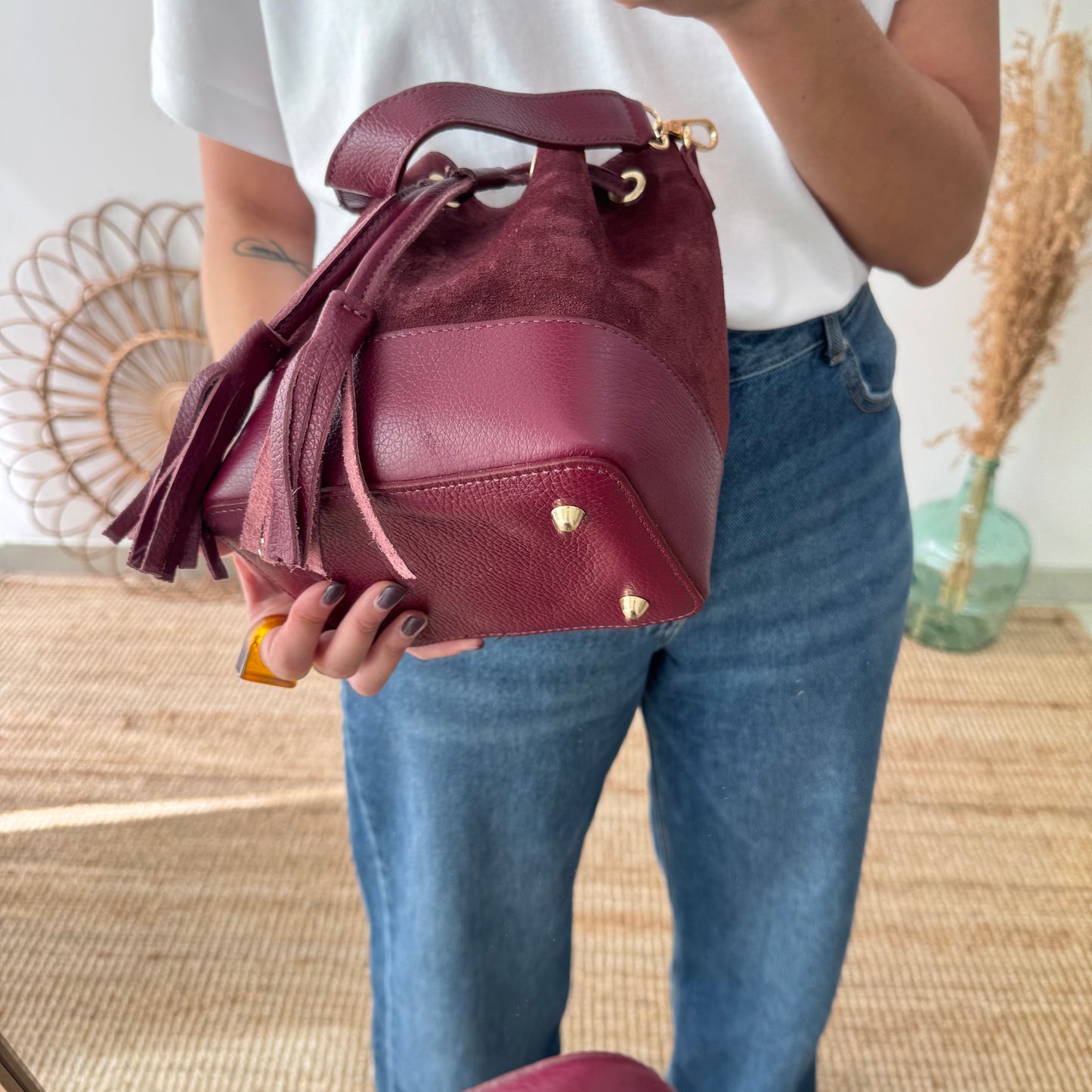 Bolso bucket serraje y piel granate pompón iniciales bordadas