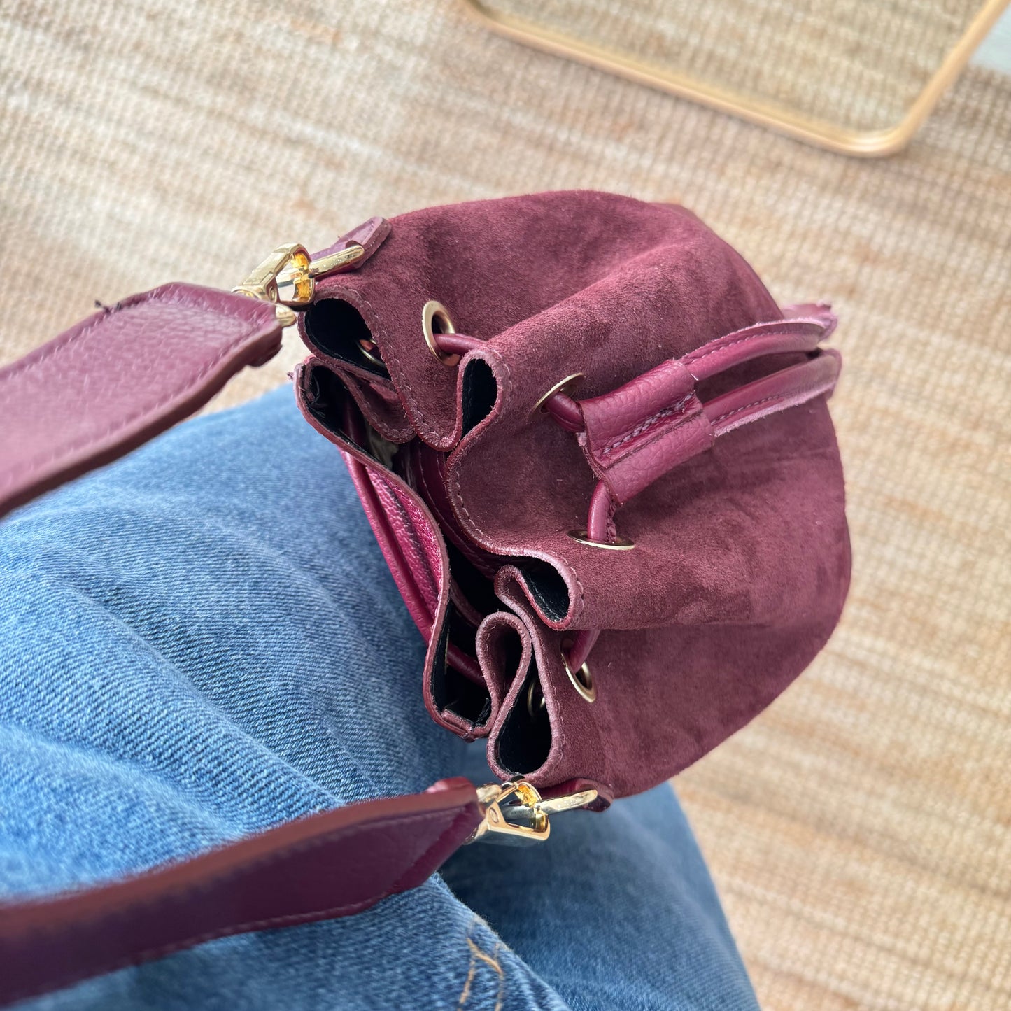Bolso bucket serraje y piel granate pompón iniciales bordadas