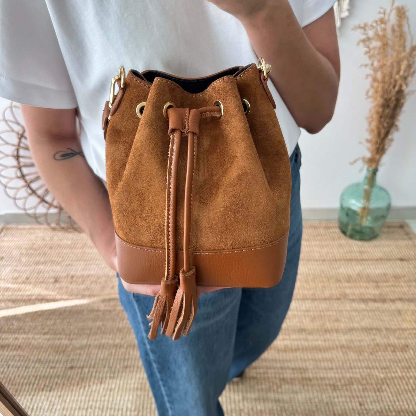Bolso bucket serraje y piel camel pompón iniciales bordadas