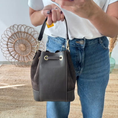 Bolso bucket serraje y piel marrón pompón iniciales bordadas