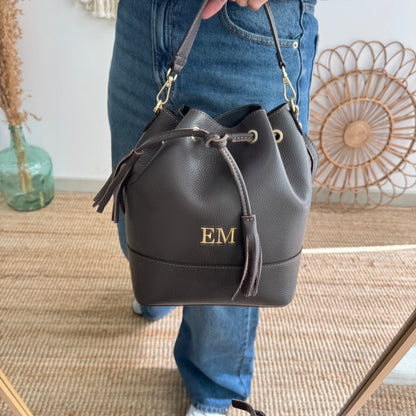Bolso bucket piel marrón grande pompón iniciales bordadas
