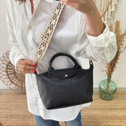 Bolso ovalado piel negra solapa iniciales bordadas