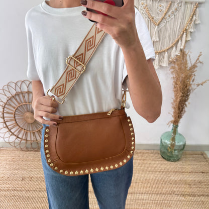 Bandolera ovalada piel tachuelas camel iniciales bordadas