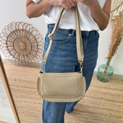 Bandolera ovalada piel tachuelas taupe iniciales bordadas