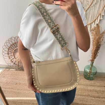 Bandolera ovalada piel tachuelas taupe iniciales bordadas