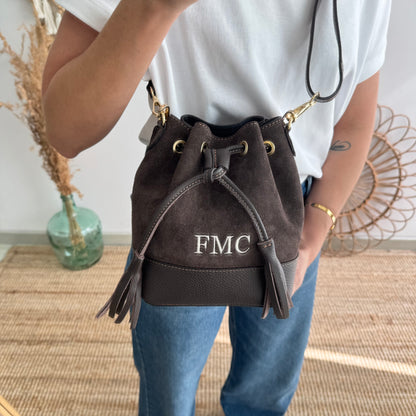 Bolso bucket serraje y piel marrón pompón iniciales bordadas