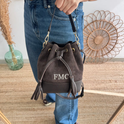 Bolso bucket serraje y piel marrón pompón iniciales bordadas