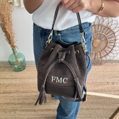 Bolso bucket serraje y piel marrón pompón iniciales bordadas