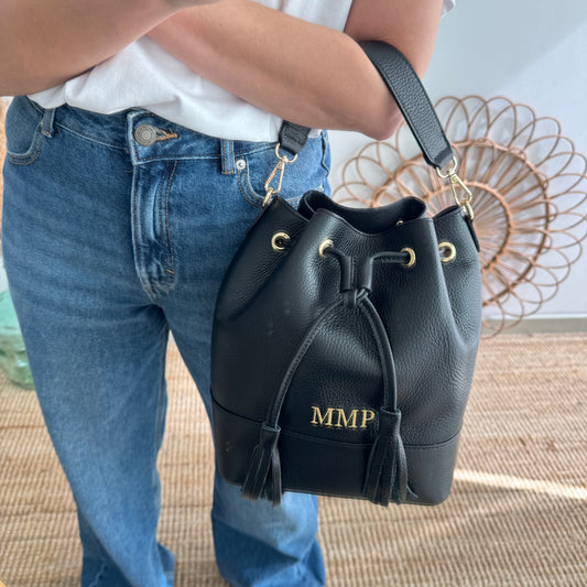 Bolso bucket piel negro grande pompón iniciales bordadas