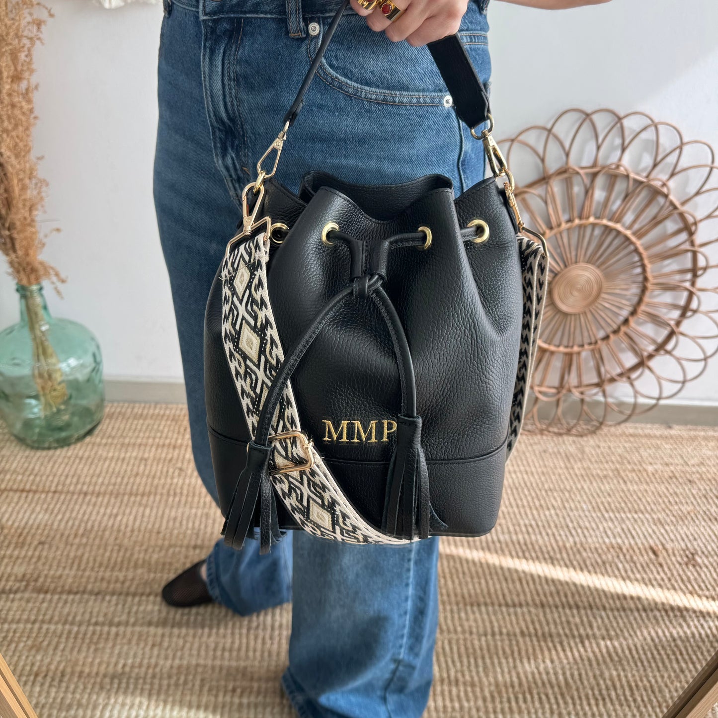 Bolso bucket piel negro grande pompón iniciales bordadas