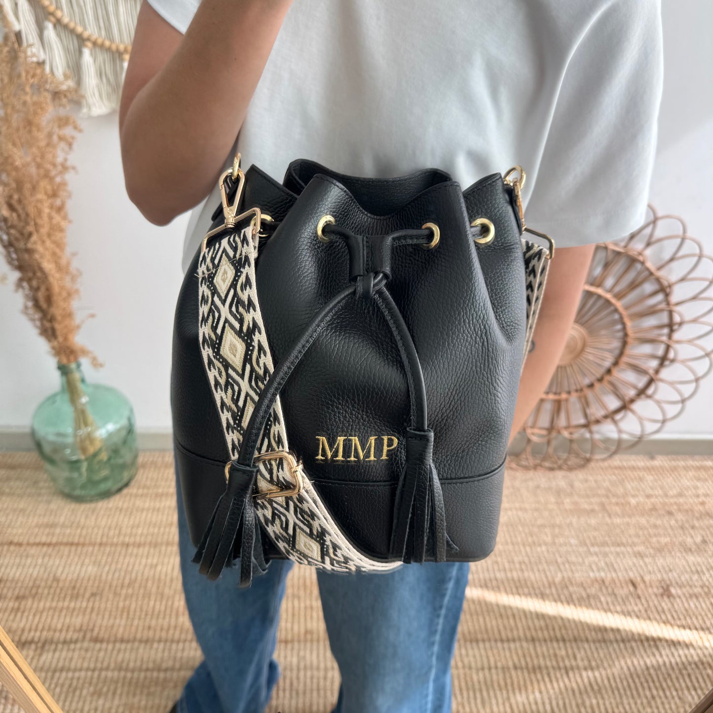 Bolso bucket piel negro grande pompón iniciales bordadas