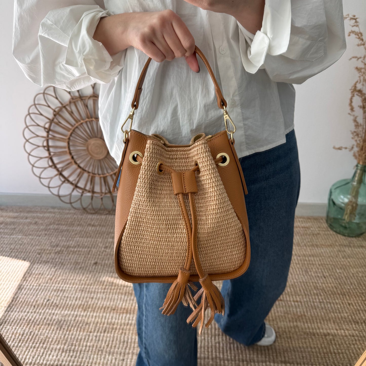 Bolso bucket combinado rafia y piel camel pompón iniciales bordadas