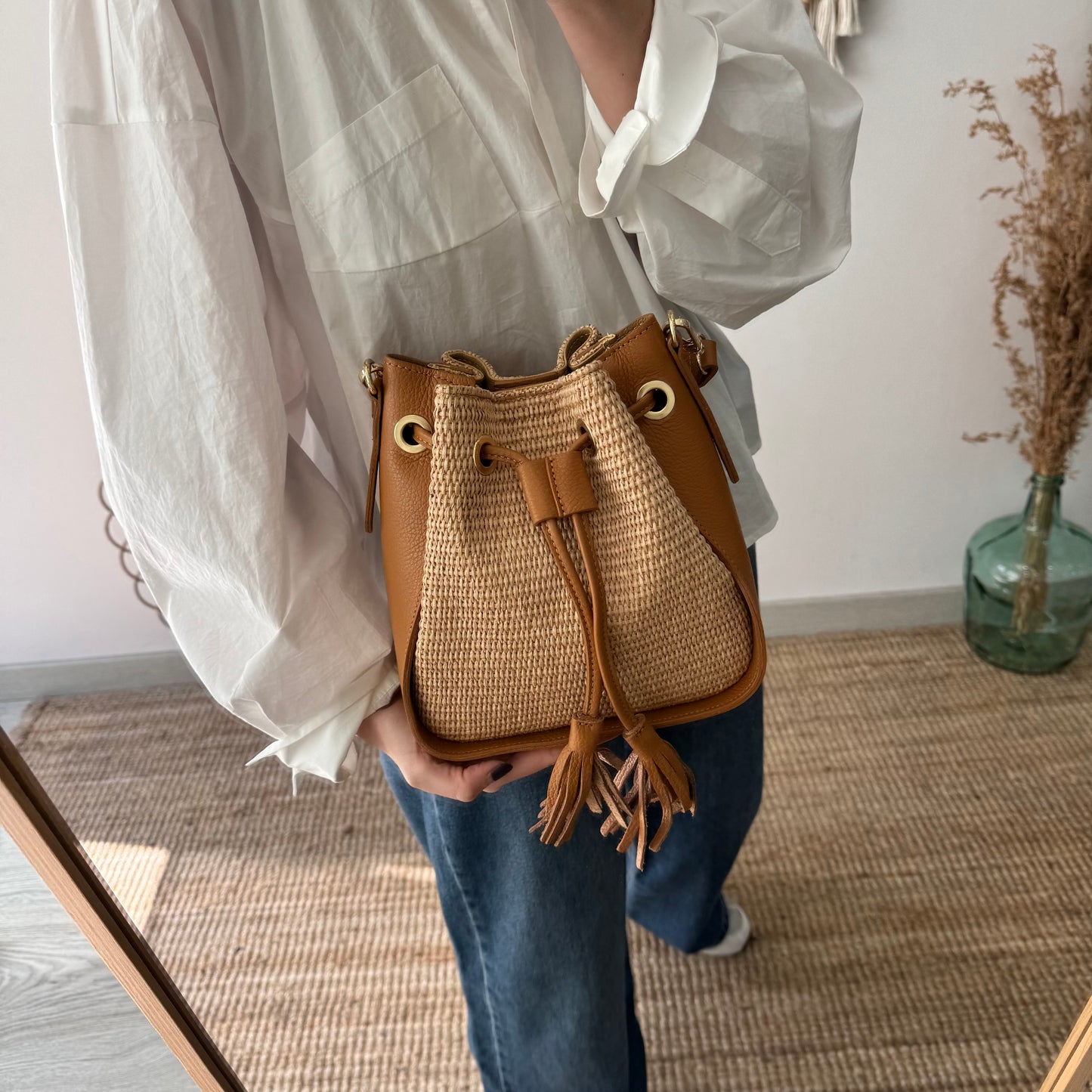 Bolso bucket combinado rafia y piel camel pompón iniciales bordadas