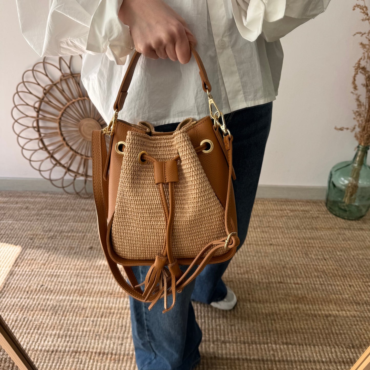 Bolso bucket combinado rafia y piel camel pompón iniciales bordadas